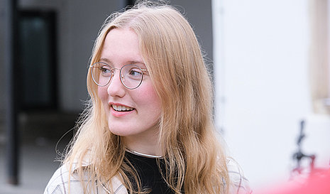 Portrait von einem blonden Mädchen mit Brille.